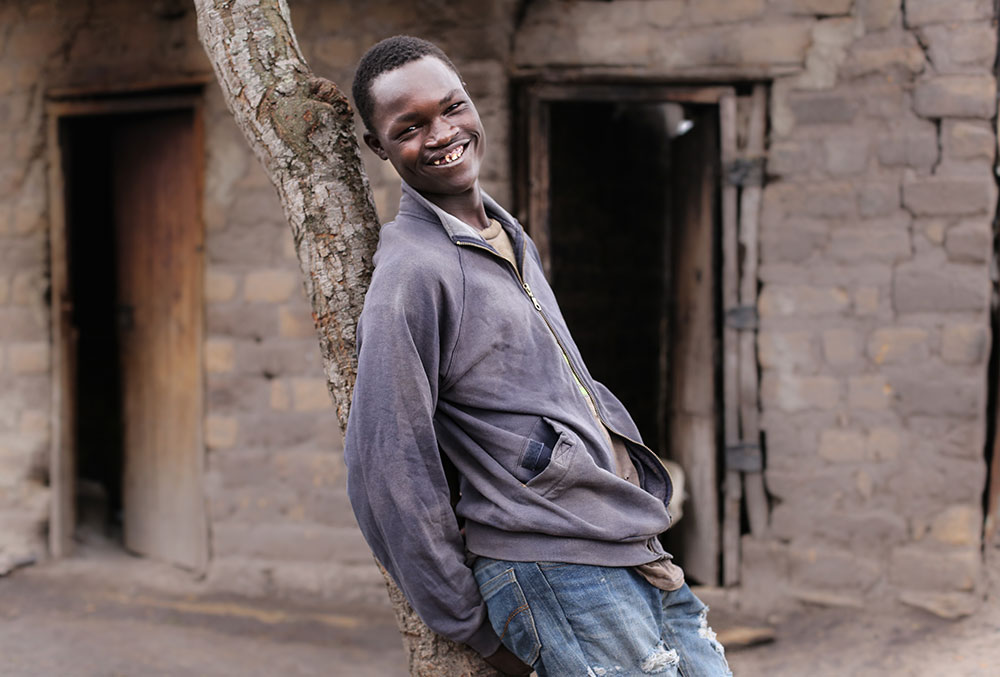 Kioko smiles while leaning against a tree after cleft surgery