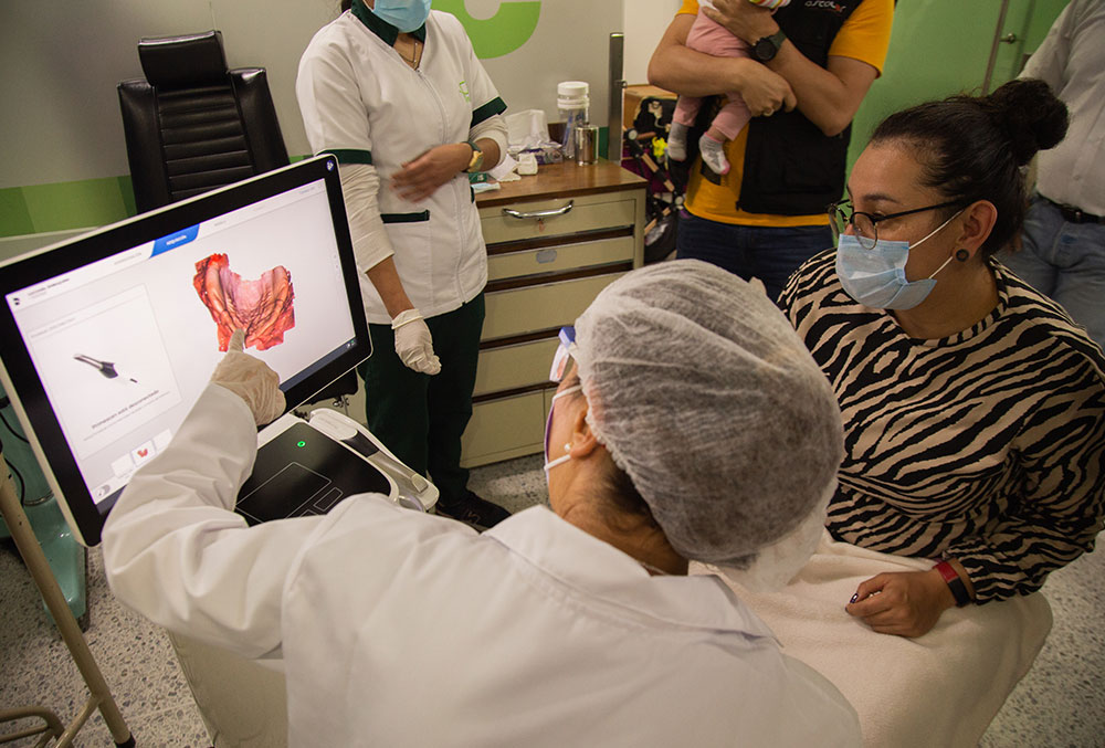 A technician at FISULAB reviews a 3D scan from Primescan with a patient's mother