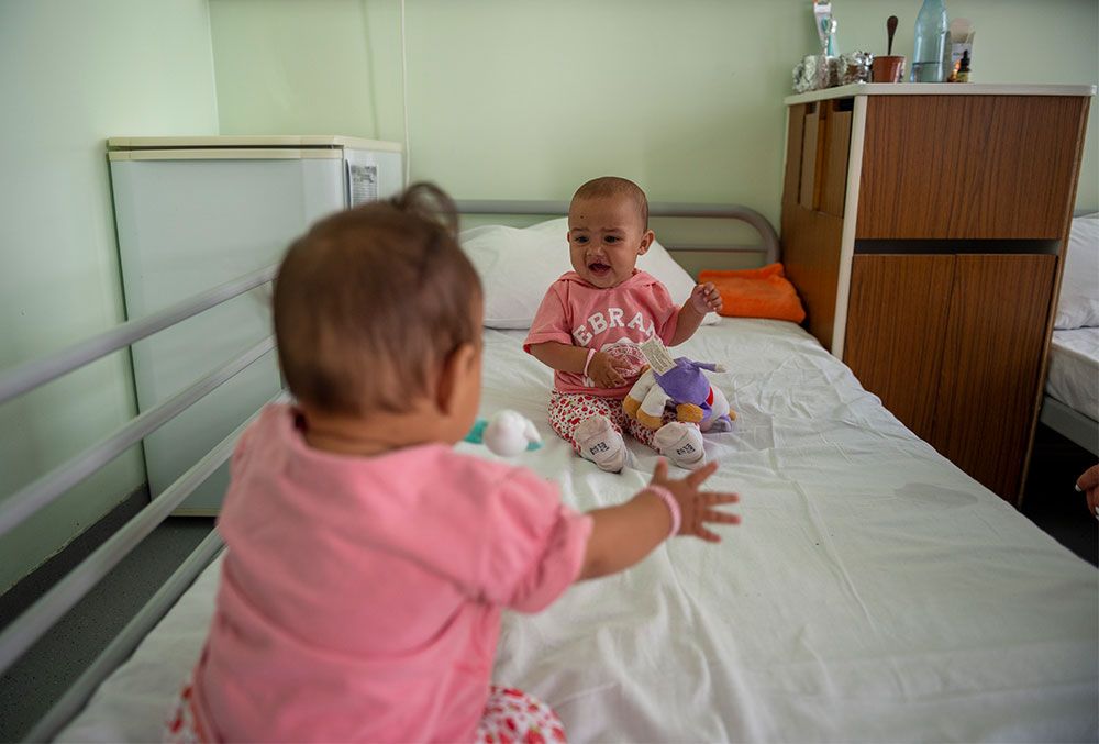 Stefania and Elena play on a hospital bed before cleft surgery