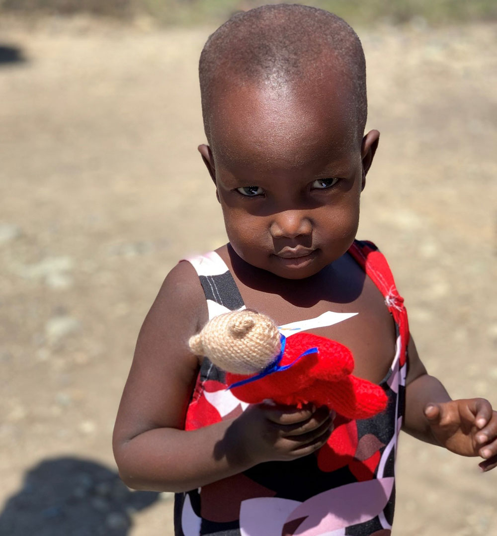 A Smile Train patient in a village in Kenya with one of the teddies Margaret knit for charity