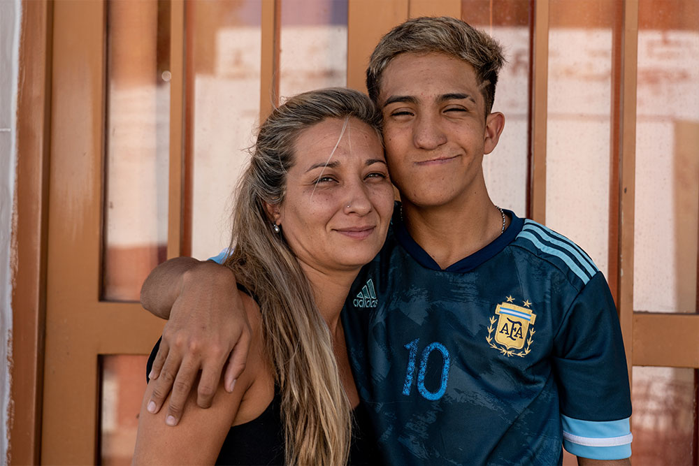 Federico with his arm around his mother